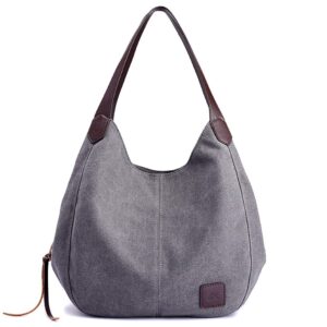 Graue Stoffhandtasche mit braunen Ledergriffen und Logoanstecker vorne.