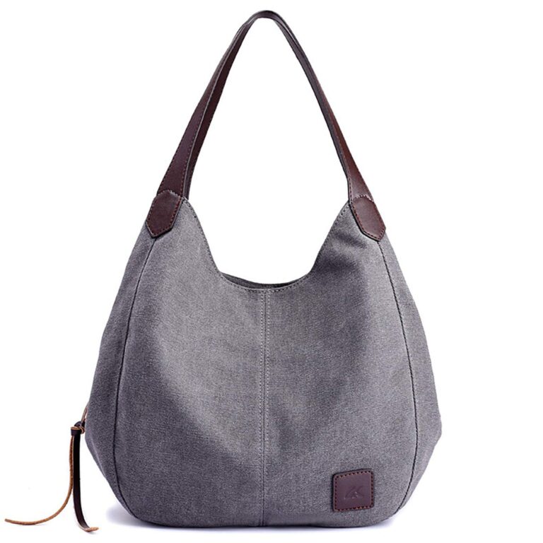 Graue Stoffhandtasche mit braunen Ledergriffen und Logoanstecker vorne. Graue Stoffhandtasche mit braunen Ledergriffen und Logoanstecker vorne.