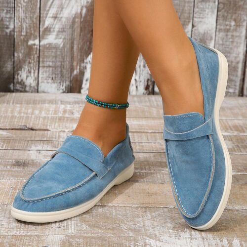 Blaue Mokassins auf Holzfußboden mit türkisfarbenem Fußkettchen. Blaue Mokassins auf Holzfußboden mit türkisfarbenem Fußkettchen.