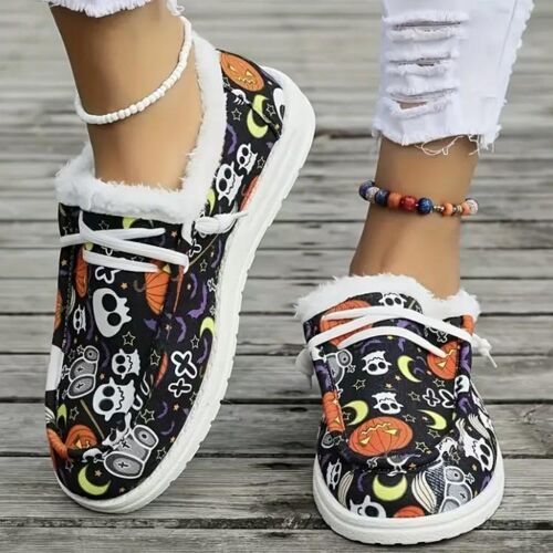 Bunte Halloween-Slipper mit Schädel-, Kürbis- und Mondmustern auf Holzsteg.