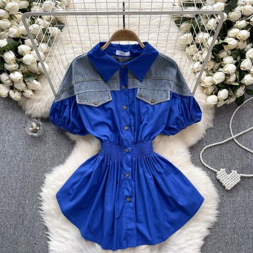 Blaues Kleid mit Jeansakzenten, umgeben von weißen Rosen.