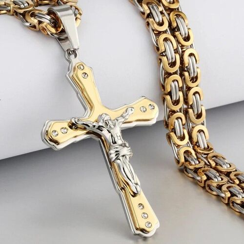 Goldkette mit großem, glänzenden Kreuzanhänger auf heller Oberfläche.