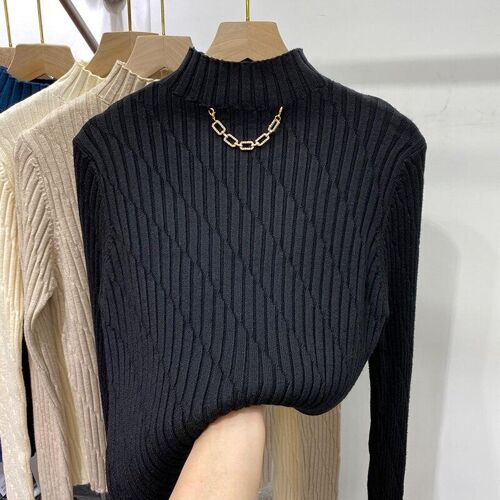 Schwarzer gerippter Pullover auf Kleiderbügel mit goldener Kette. Schwarzer gerippter Pullover auf Kleiderbügel mit goldener Kette.