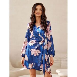 Frau trägt blaues blumiges Kleid in einem elegant eingerichteten Zimmer.