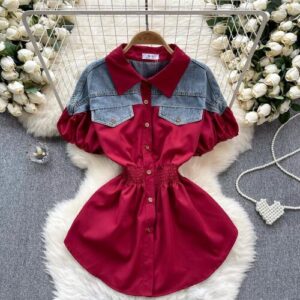 Rote Bluse mit Jeansakzent auf Fellteppich, umgeben von weißen Rosen.