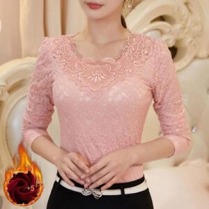 Rosa Spitzenbluse mit floralem Muster und langen Ärmeln vor hellem Hintergrund.