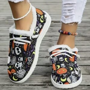 Bunte Halloween-Schuhe mit Totenkopf- und Kürbismuster auf Holzoberfläche.