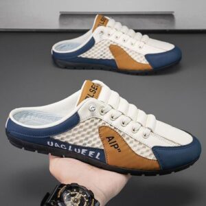 Sportschuhe in Weiß und Blau mit Hand gehalten, auf grauem Hintergrund.