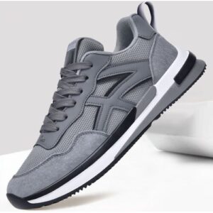 Grauer Sneaker mit schwarzen Akzenten, schwebend vor neutralem Hintergrund.