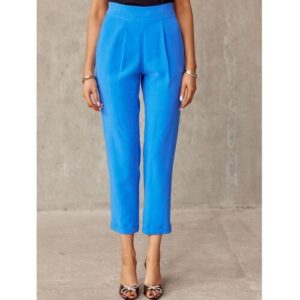 Person trägt blaue High-Waist-Hose vor grauem Hintergrund.