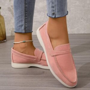 Frau trägt rosa Loafer und blaue Jeans.