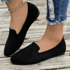 Schwarze Loafers auf Holzdeck, zerrissene Jeans, goldenes Fußkettchen.
