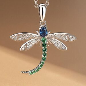 Silberner Libellen-Anhänger mit blauen und grünen Edelsteinen auf einer Kette.