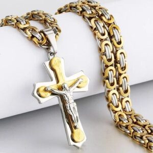 Goldene Kette mit silbernem Kreuzanhänger auf weißem Hintergrund.