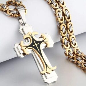 Kreuzanhänger aus Metall mit goldenen und silbernen Details neben passender Metallkette.