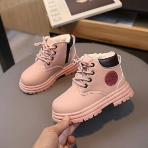 Zwei rosa Kinderschuhe mit Schnürung auf einem Tisch.