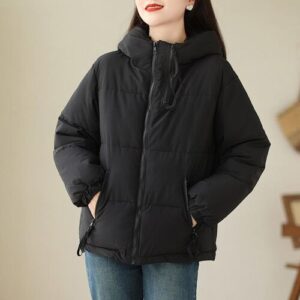 Person trägt schwarze Daunenjacke mit Kapuze und Reißverschluss.