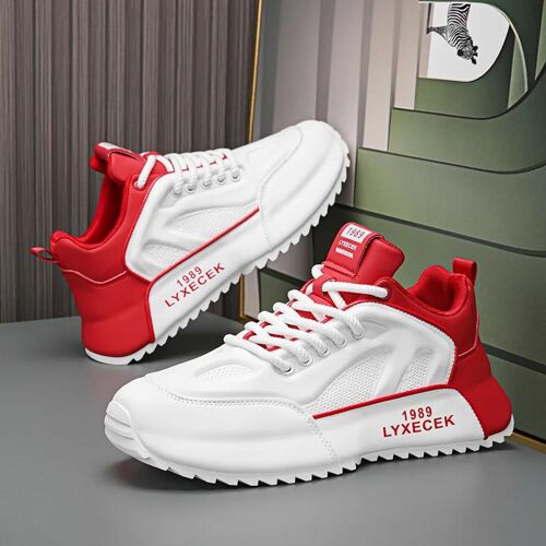 Weiße Sneaker mit roten Details auf grauem Hintergrund.