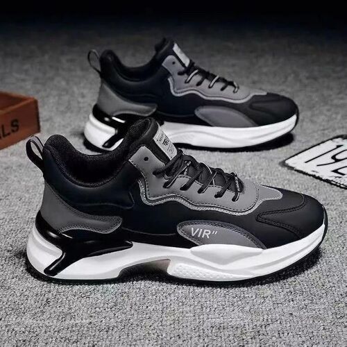 Zwei schwarze und graue Sneakers auf einem grauen Hintergrund. Zwei schwarze und graue Sneakers auf einem grauen Hintergrund.
