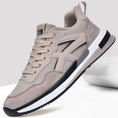 Beiger Sneaker mit schwarzer und weißer Sohle auf grauem Hintergrund.